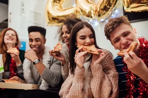 A group celebrating together over pizza