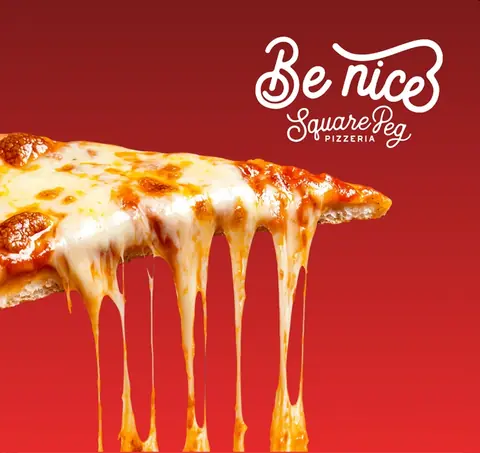 The Be Nice pizza wall backdrop at Square Peg Pizzeria — a cheese pull across a red banner