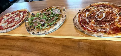 Three Square Peg pizzas on a board
